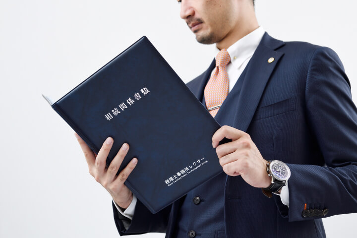 相続専門の税理士事務所レクサー代表税理士伊東秀明が真剣な眼差しで相続関係書類を見ている写真